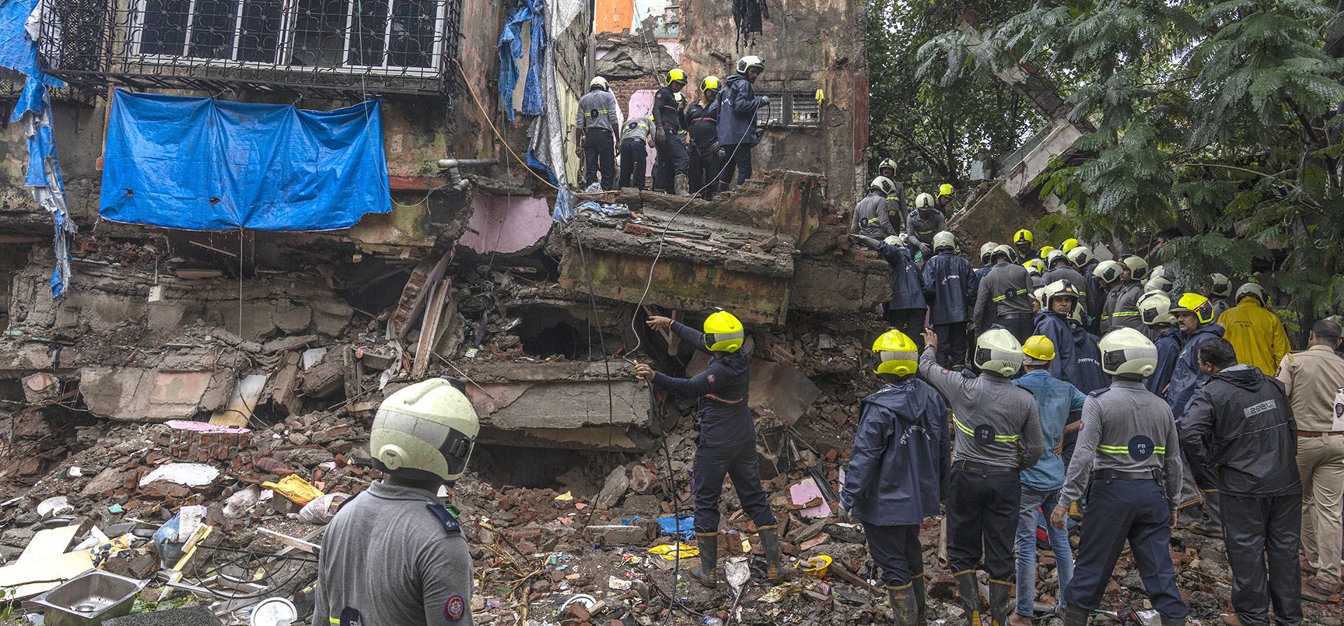 Rescatistas buscan sobrevivientes entre los escombros de un edificio residencial de cuatro pisos que se derrumbó en Mumbai, India, el martes 28 de junio de 2022. Al menos tres personas murieron y más resultaron heridas luego de que el edificio se derrumbara el lunes por la noche.