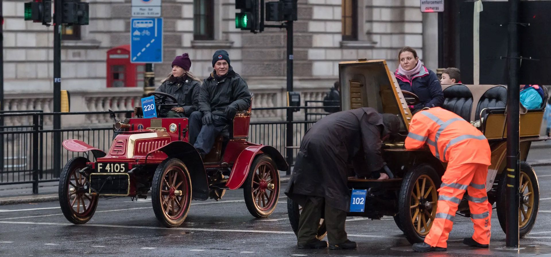 Londres, Reino Unido. Un automovilista y un mecánico de RAC intentan arreglar un coche antiguo averiado en Whitehall durante el