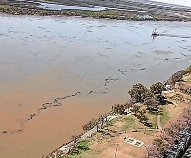 Un surco negro de cientos de metros se visualiza en el Río Paraná frente a Rosario.