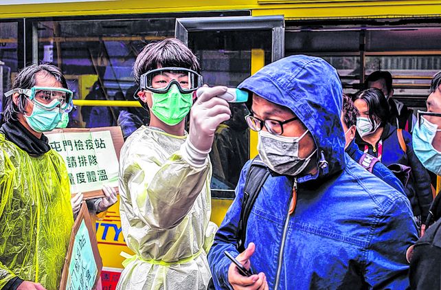 Coronavirus. Un voluntario de salud toma la temperatura a una pasajera