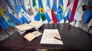 El acta acuerdo junto a las banderas de las provincias que participaron de la rúbrica.