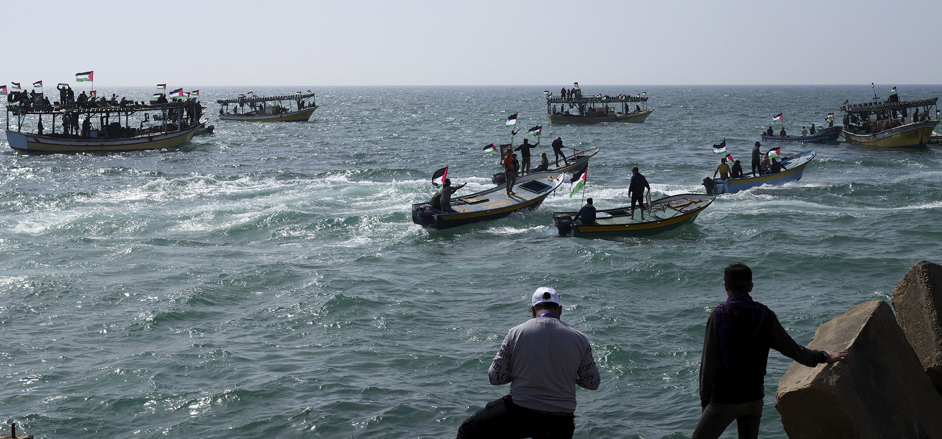 Palestinos ondean sus banderas nacionales durante un mitin que marca el 46° aniversario del Día de la Tierra, en las aguas del mar Mediterráneo en el puerto de pescadores de la ciudad de Gaza. Ciudadanos palestinos de Israel y en Cisjordania y Gaza marcan el