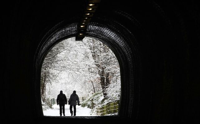 Una pareja camina por un parque nevado en Auchendinny