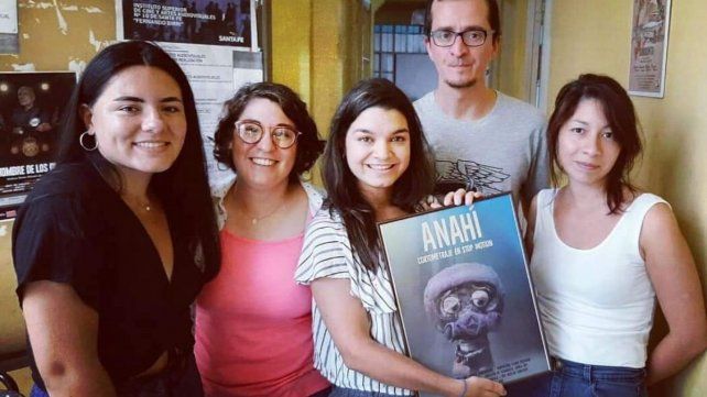 Aranza Sonderegger sosteniendo el cuadro de Anahí junto a sus compañeros de trabajo