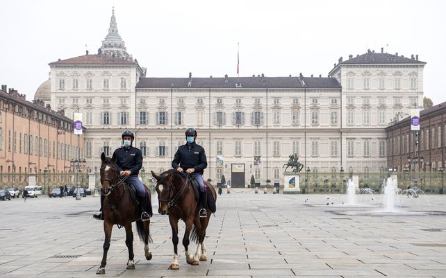 La policía montada cruza la Piazza Castello de Turín