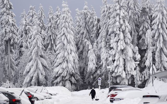 Una mujer quita la nieve frente a su casa después de una fuerte nevada en Oberhof