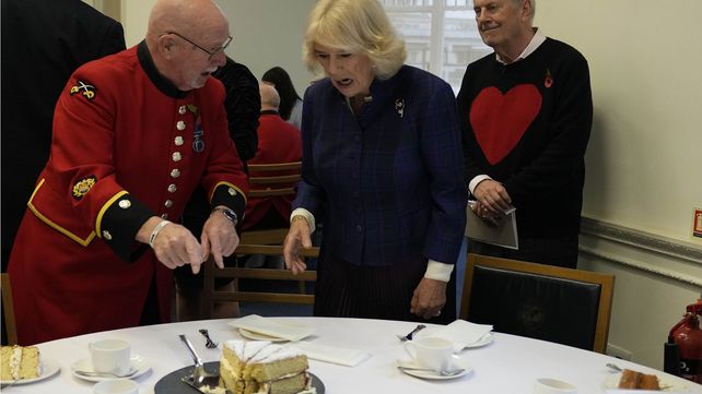 Un militar jubilado de Chelsea Roy Palmer señala el pastel cuando la británica Camilla, la duquesa de Cornualles, se une a los niños y a los residentes del hogar de cuidados para un recital y una fiesta de té 