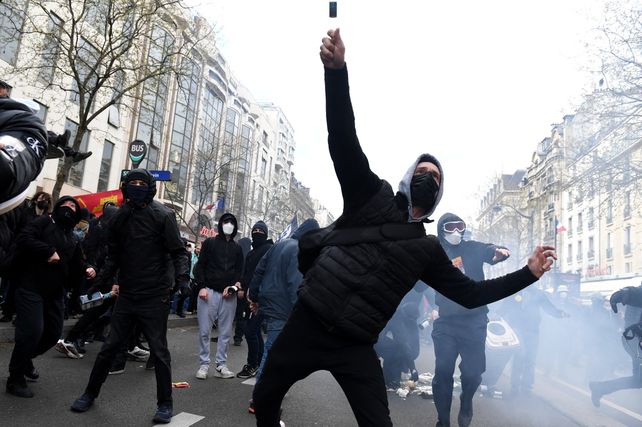 Un manifestante lanza una botella a la policía antidisturbios durante la manifestación de este jueves en París.