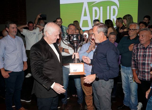 Daniel Tramontini le entrega el trofeo 2025 a los referentes de APUR