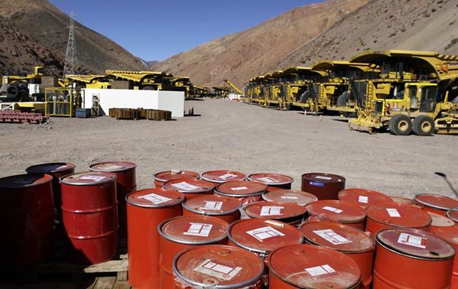Lbor suspendida. Maquinarias para la minería y barriles con químicos en lo alto de la montaña.