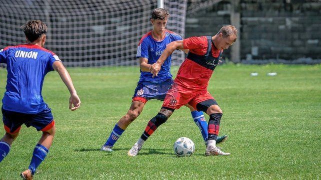 Arnaldo González sostiene el balón ante la marca de un defensor de Unión.