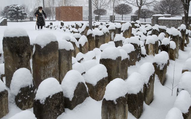 Un anciano checheno&nbsp; ora en un cementerio cubierto por la nieve