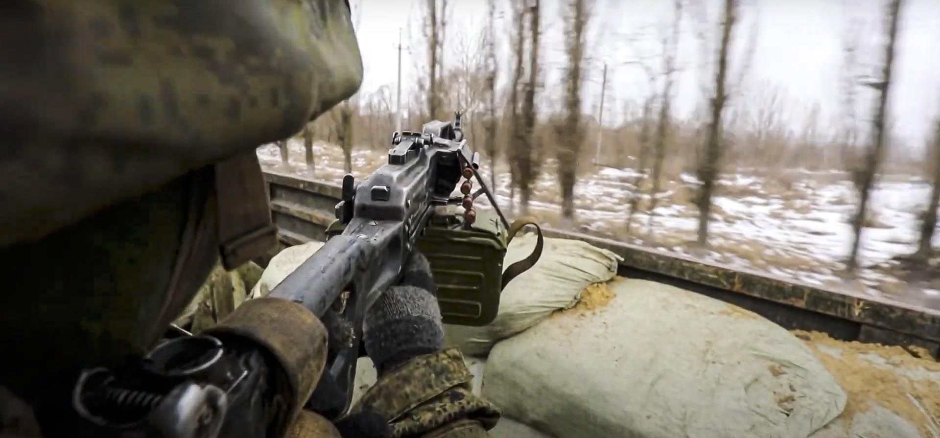 Captura de video publicado por el Servicio de Prensa del Ministerio de Defensa de Rusia el jueves 3 de marzo de 2022, un soldado ruso apunta con un arma desde un camión militar ruso mientras conduce por un lugar no revelado en Ucrania.