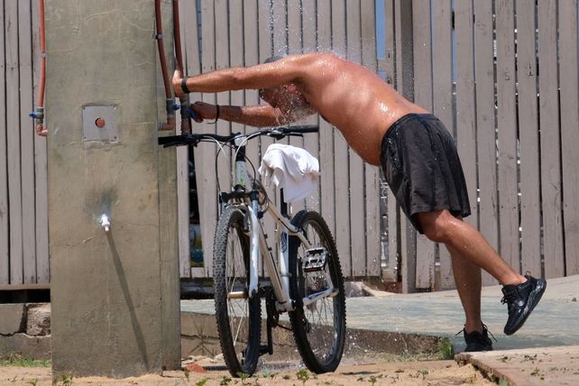 Refrescada. Un ciclista calma el sopor en una canilla pública.