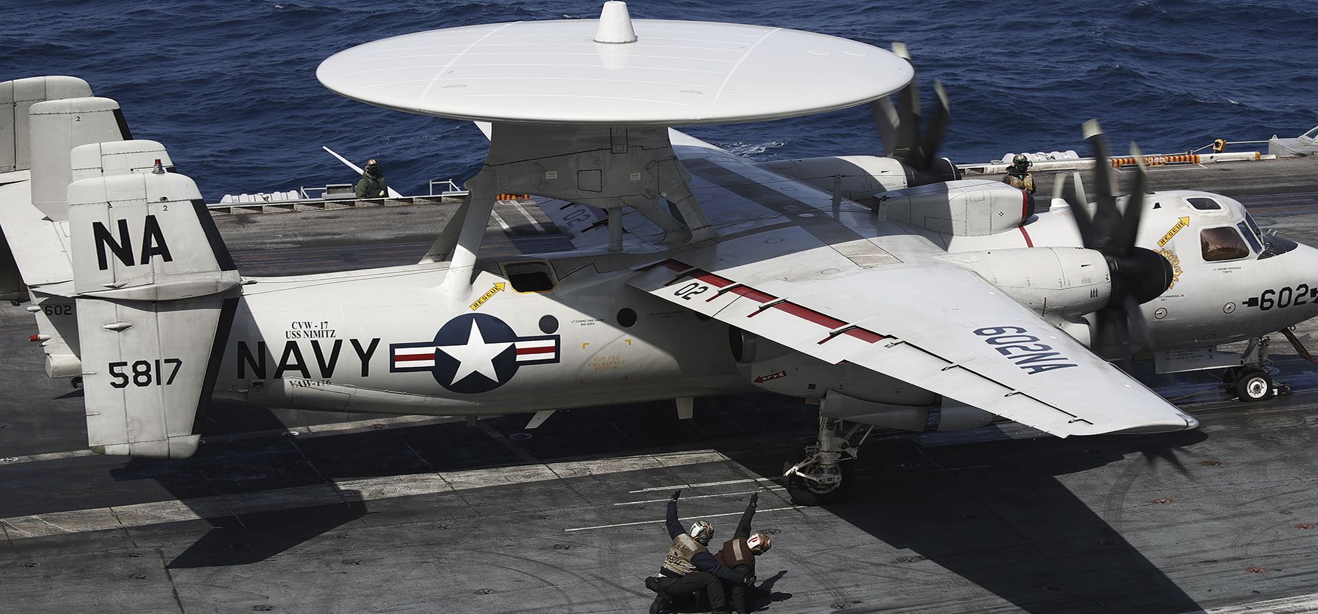 Un avión de la Marina de los EE. UU. Hawkeye y miembros de la tripulación se ven en la cubierta de vuelo del USS Nimitz frente a la costa de Busan, Corea del Sur, el lunes 27 de marzo de 2023. El portaaviones estadounidense de propulsión nuclear y su grupo de batalla comenzaron ejercicios con Corea del Sur, horas después de que Corea del Norte disparara dos misiles balísticos de corto alcance en una aparente protesta por la expansión de los ejercicios de los aliados. (Jeon Heon-kyun/Foto de la piscina vía AP)