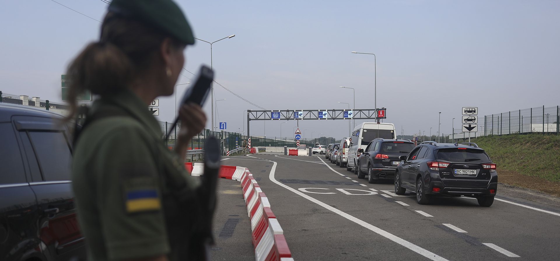 Un oficial de la guardia fronteriza ucraniana observa una fila de autos en el cruce fronterizo de Krakovets - Korcheva en Krakovets, Ucrania, el martes 16 de agosto de 2022. Una renovación del cruce fronterizo de Krakovets es parte del proyecto de frontera abierta entre Ucrania y Polonia.