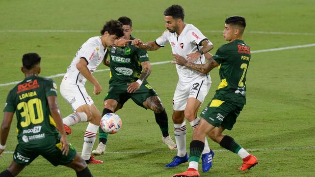 Enredados. Giani y Scocco intentan hacerse de la pelota ante la marca. En la crónica de los 90