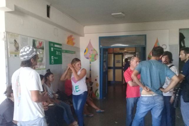 Mariela de remera blanca y Marcos de azul y de espaldas a la entrada del área donde está internada su hija.