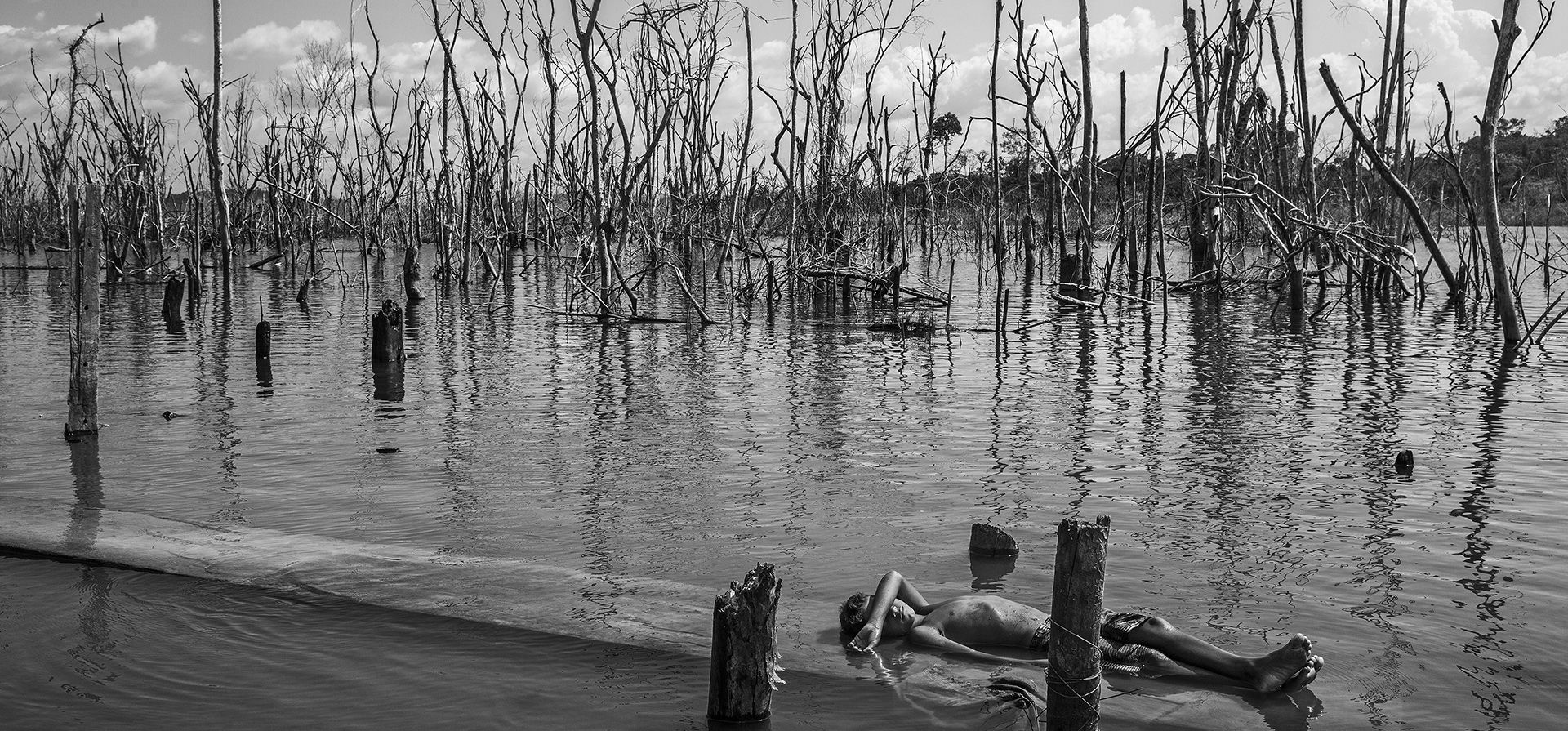 Imagen de una serie titulada Amazonian Dystopia, de Lalo de Almeida para Folha de Sao Paulo/Panos Pictures que ganó el premio World Press Photo Long-Term Project, muestra a un niño descansando sobre el tronco de un árbol muerto. en el río Xingu en Paratizao, una comunidad ubicada cerca de la represa hidroeléctrica Belo Monte, Par·, Brasil, el 28 de agosto de 2018. (Lalo de Almeida para Folha de Sao Paulo/Panos Pictures/World Press Photo vía AP)