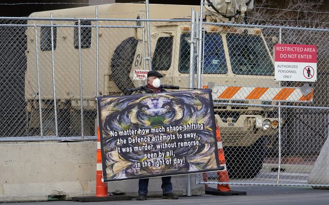 Un manifestante sostiene su cartel frente al Centro de Gobierno del Condado de Hennepin