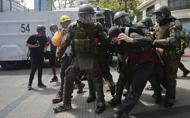 Policías detienen a un manifestante durante una protesta organizada por estudiantes de secundaria contra el regreso a las escuelas porque creen que no hay suficientes medidas de seguridad contra el coronavirus en Santiago de Chile.