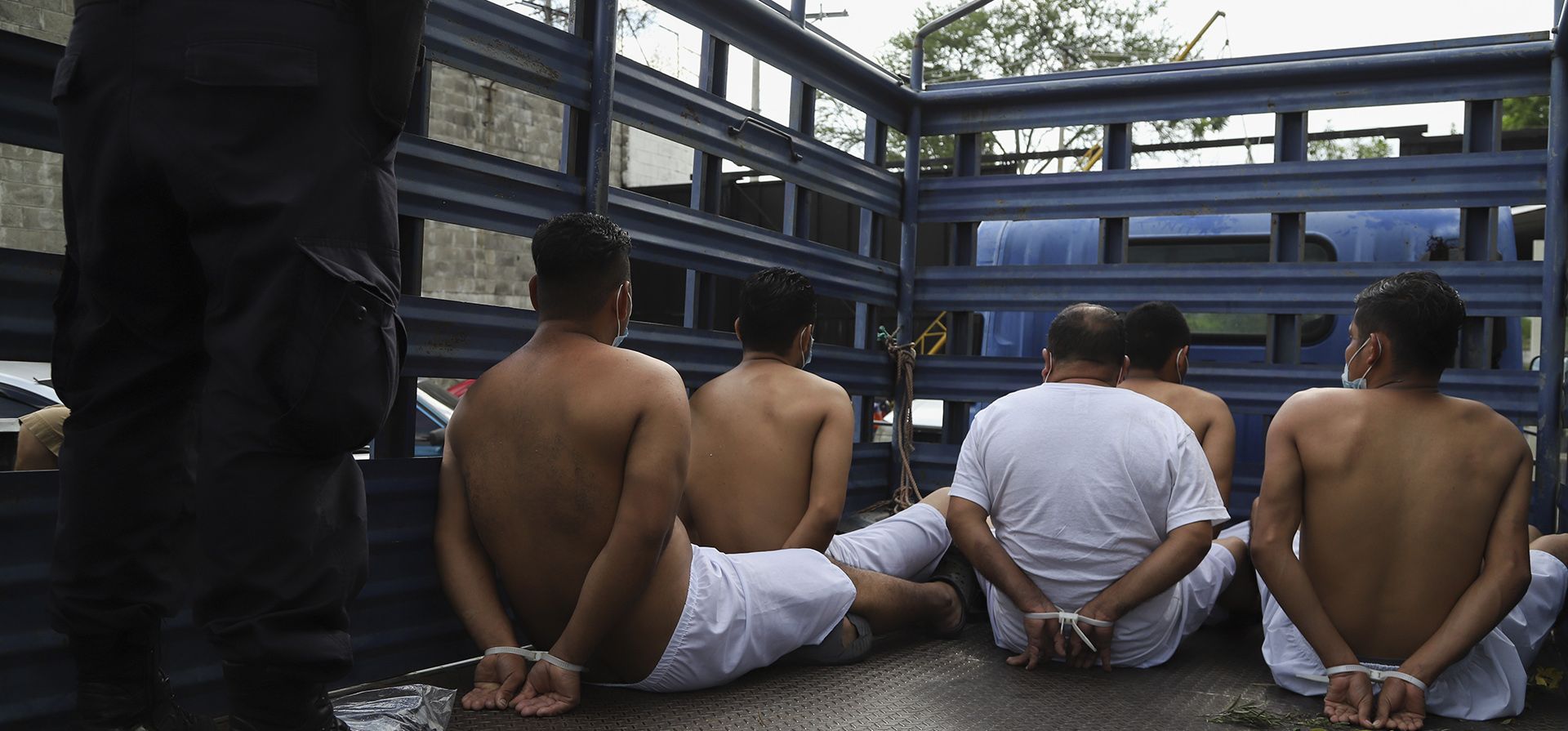 Personas arrestadas por la policía por tener presuntos vínculos con pandillas esperan esposadas en la parte trasera de un camión para ser trasladadas a una prisión en la Delegación de Policía de San Bartolo en Soyapango, El Salvador, el miércoles 17 de agosto de 2022.