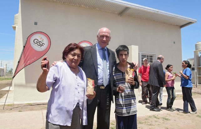 El gobernador junto a dos adjudicatarios en el Parque Habitacional Ibarlucea.