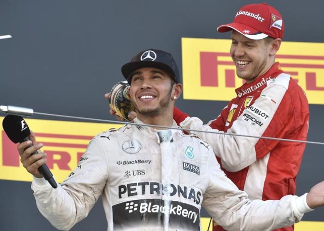 Hamilton celebra el triunfo junto a su compatriota y piloto de Ferrari