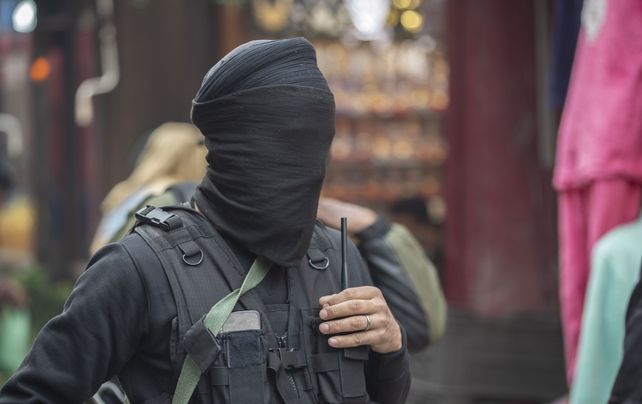 Un miembro del Grupo de Operaciones Especiales (SOG) de la policía de Jammu y Cachemira, con el rostro cubierto, llega para una operación de verificación sorpresa en un concurrido mercado en Srinagar, Cachemira controlada por India, el jueves 11 de noviembre de 2021.