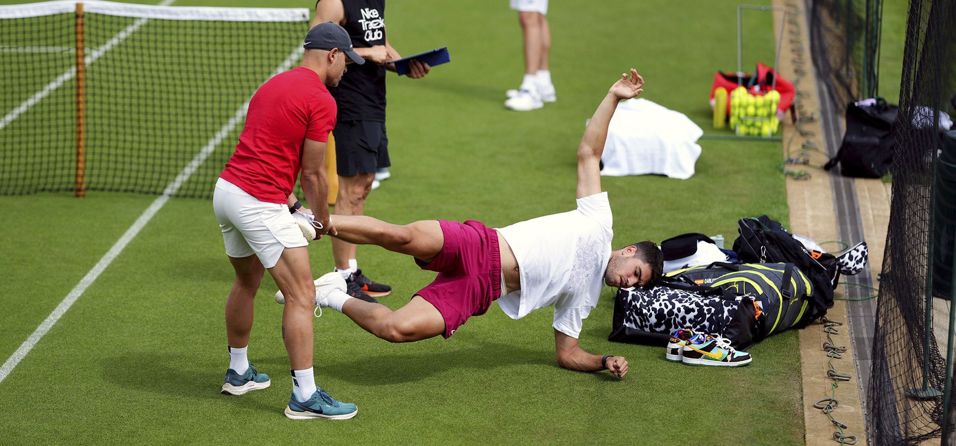 El español Carlos Alcaraz se estira durante una sesión de entrenamiento en el All England Lawn Tennis and Croquet Club en Wimbledon antes del Campeonato de Wimbledon, que comienza el 1 de julio, en Londres, el lunes 24 de junio de 2024. (John Walton/PA vía AP) El español Carlos Alcaraz se estira durante una sesión de entrenamiento en el All England Lawn Tennis and Croquet Club en Wimbledon antes del Campeonato de Wimbledon, que comienza el 1 de julio, en Londres, el lunes 24 de junio de 2024. (John Walton/PA vía AP)