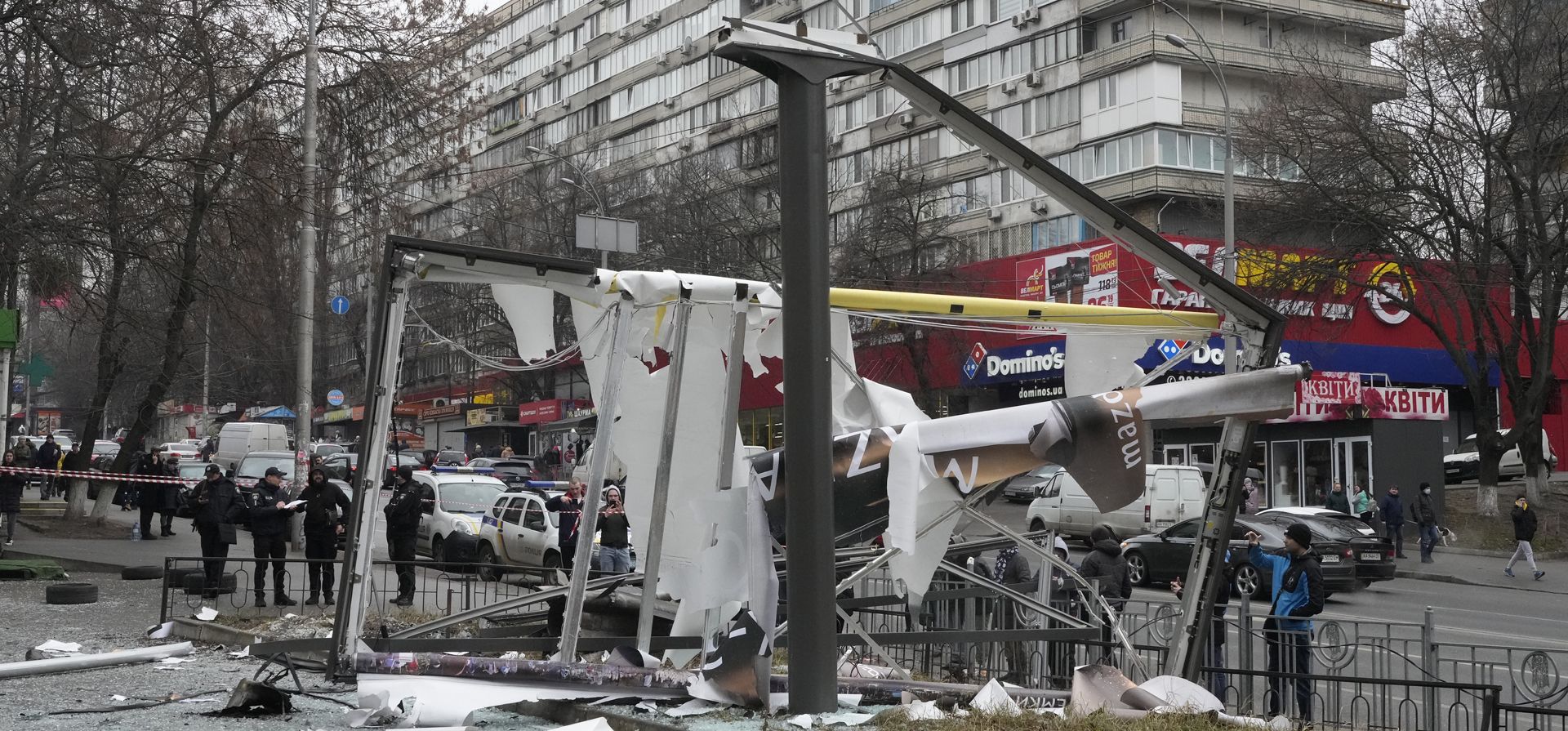 La gente examina las consecuencias del bombardeo ruso en Kiev, Ucrania, el jueves 24 de febrero de 2022. Las tropas rusas lanzaron su ataque anticipado contra Ucrania. Se escucharon grandes explosiones antes del amanecer en Kyiv, Kharkiv y Odesa.
