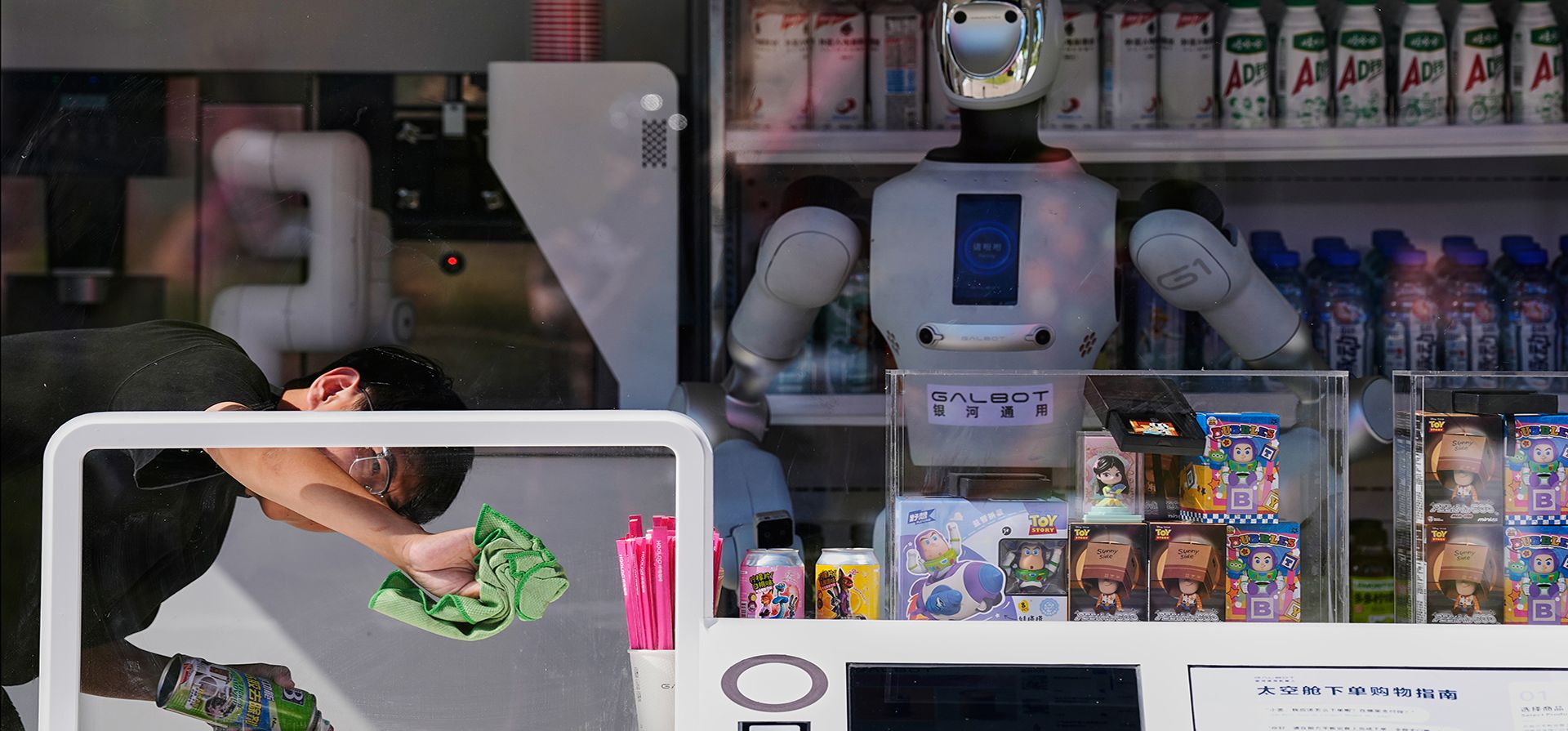 Un trabajador limpia el panel de una ventana junto a un robot humanoide compacto en una tienda de bebidas en un parque en Beijing, el miércoles 9 de septiembre de 2026. (Foto AP/Andy Wong) Un trabajador limpia el panel de una ventana junto a un robot humanoide compacto en una tienda de bebidas en un parque en Beijing, el miércoles 9 de septiembre de 2026. (Foto AP/Andy Wong)