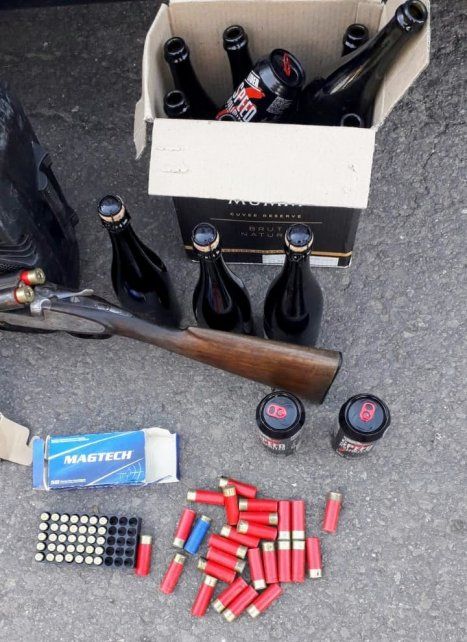 Una escopeta calibre 16 con cartuchos y bebidas alcohólicas, el material secuestrado de una de las viviendas. 