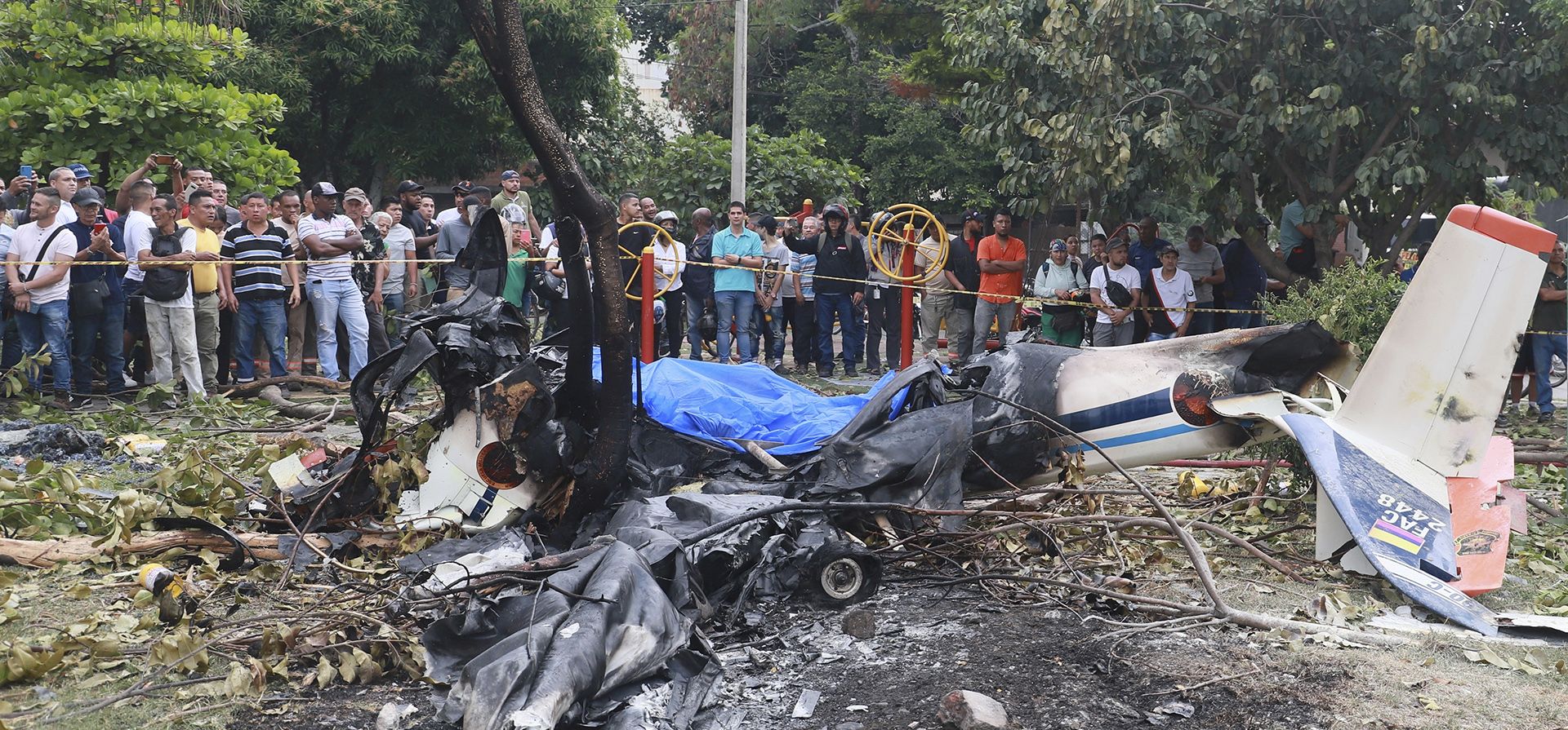 Residentes observan los restos de un avión de la Fuerza Aérea Colombiana que se estrelló en un área urbana de Cali, Colombia, el martes 3 de octubre de 2023. Según las autoridades, una persona a bordo murió y otra sobrevivió. (Foto AP/Juan B. Díaz) Residentes observan los restos de un avión de la Fuerza Aérea Colombiana que se estrelló en un área urbana de Cali, Colombia, el martes 3 de octubre de 2023. Según las autoridades, una persona a bordo murió y otra sobrevivió. (Foto AP/Juan B. Díaz)