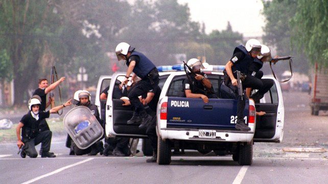 20/12/2001.Policías se ponen a cubierto luego  que, desde el interior de la calle  Amenábar y Avellaneda , les disparan con armas de fuego. En ese tiroteo resulto herido Claudio Berón, cronista de La Capital .
