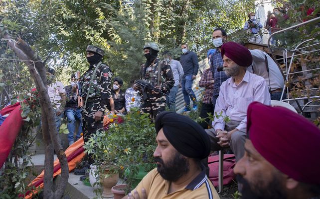Soldados paramilitares indios montan guardia mientras familiares de Satinder Kour, una de las dos maestras asesinadas a tiros por asaltantes el jueves, lloran frente a su residencia en Srinagar, Cachemira, controlada por India, el jueves 7 de octubre de 2021.