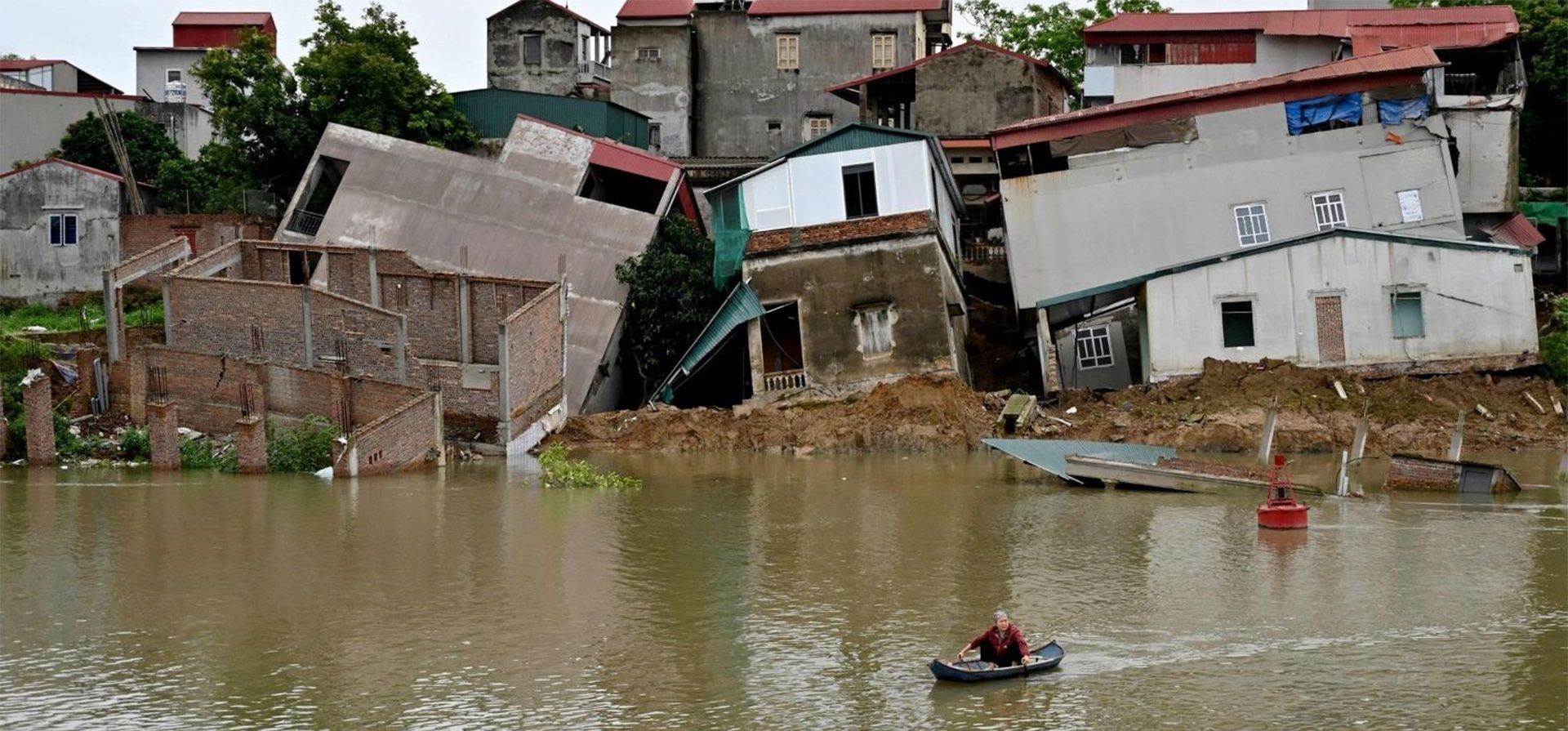 Una mujer rema junto a casas dañadas a orillas del río Cau después de un deslizamiento de tierra y donde los residentes fueron evacuados en Bac Ninh, Vietnam. Foto: Nhac NGUYEN / AFP Una mujer rema junto a casas dañadas a orillas del río Cau después de un deslizamiento de tierra y donde los residentes fueron evacuados en Bac Ninh, Vietnam. Foto: Nhac NGUYEN / AFP
