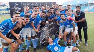 Tras el triunfo, el goleador Ortigoza sostiene el cheque junto a sus compañeros.