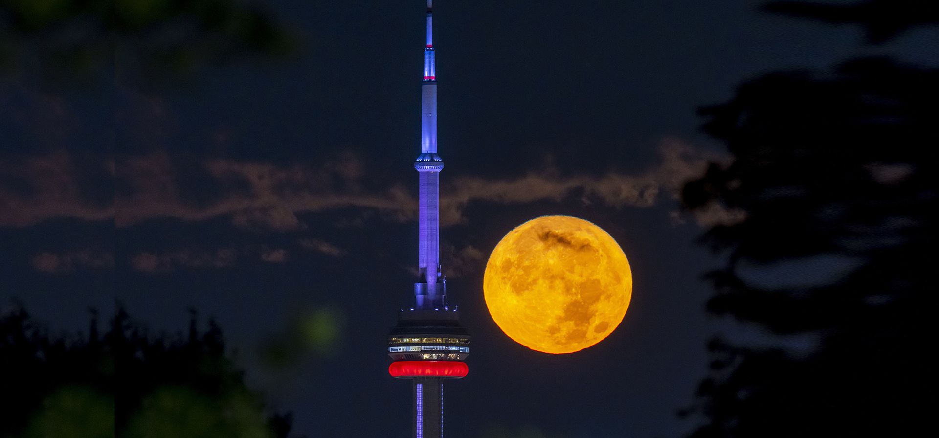 La Super Luna Azul de agosto se pone detrás de la torre CN en Toronto el miércoles 30 de agosto de 2023.  (Frank Gunn/The Canadian Press vía AP)