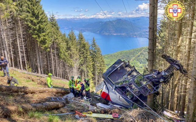 Rescatistas trabajan junto a los restos de un teleférico después de que se derrumbó cerca de la cima de la línea Stresa-Mottarone en la región de Piamonte, norte de Italia, el domingo 23 de mayo de 2021.