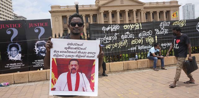 Un manifestante sostiene una pancarta con el retrato del ex primer ministro Mahinda Rajapaksa cerca de la oficina del presidente en Colombo