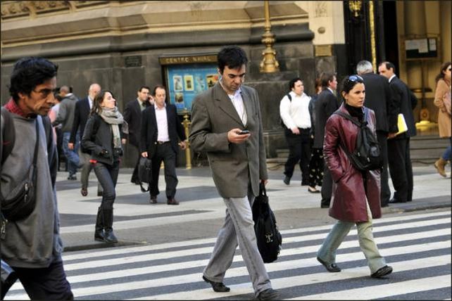Podrían sancionar a los peatones que crucen la calle mirando el celular