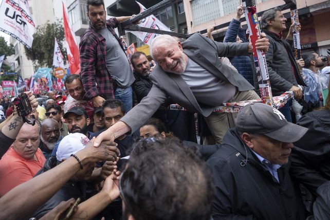 Final de campaña, Lula le da la mano a un simpatizante el día previo al balotaje en Brasil.