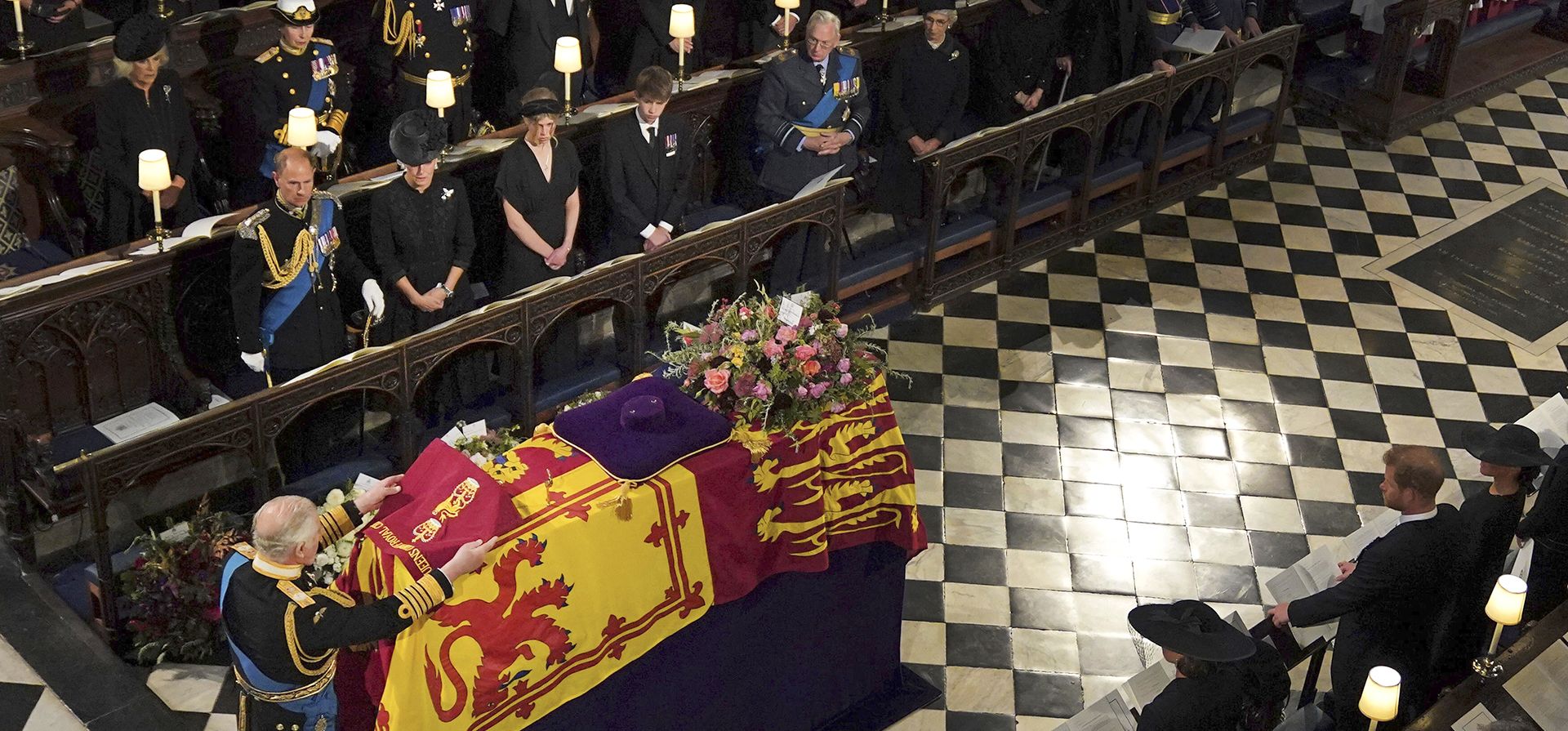 El Rey Carlos III coloca el Color del Campamento de la Compañía de la Reina de la Guardia de Granaderos en el ataúd de la Reina Isabel II, durante el servicio de entierro de la monarca, en la Capilla de San Jorge, en Windsor, Inglaterra, el lunes 19 de septiembre de 2022. La Reina, quien murió a los 96 años el 8 de septiembre, será enterrada en Windsor junto a su difunto esposo, el príncipe Felipe, quien murió el año pasado. (Victoria Jones/Foto de la piscina vía AP)