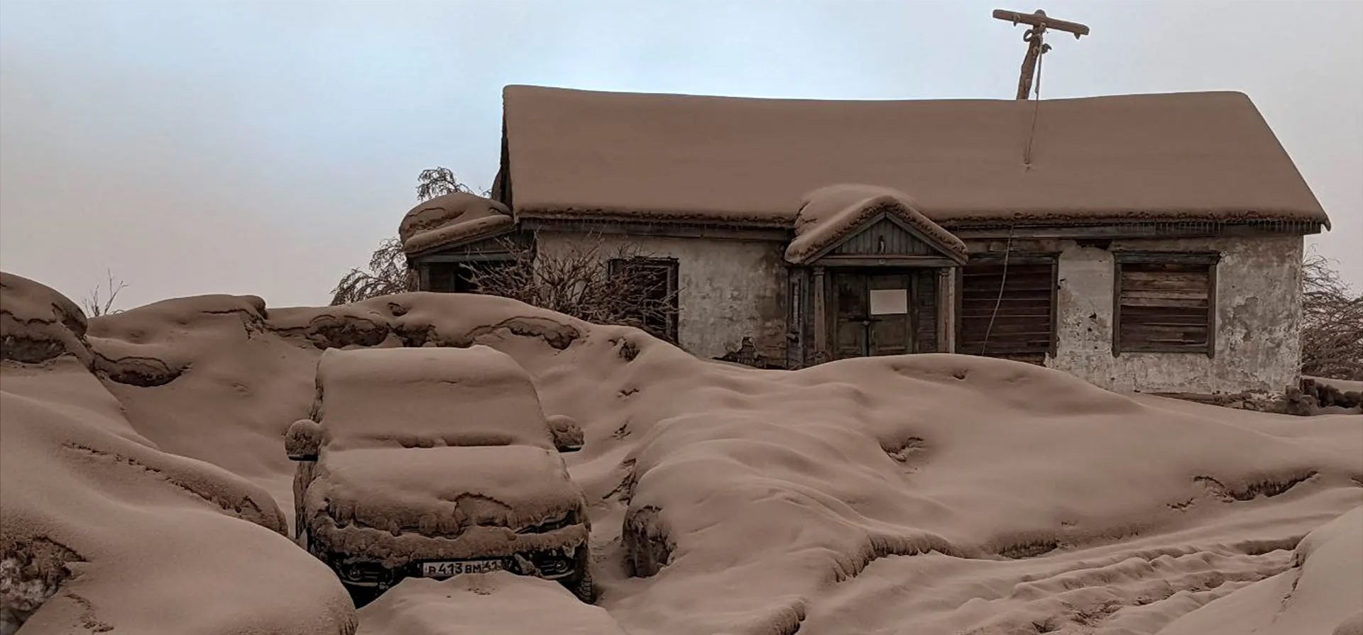 Kamchatka, Rusia. Una casa y un coche cubiertos de polvo volcánico tras la erupción del volcán Shiveluch. Fotografía: Instituto de Vulcanología y Sismología/Reuters