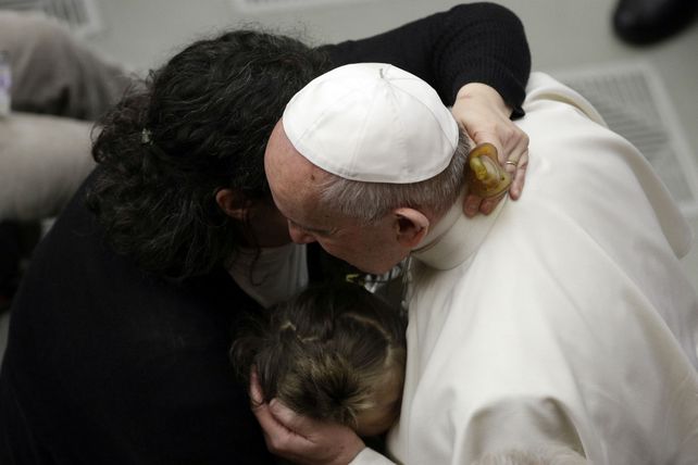 Afecto. Francisco abraza a una mujer y a su hija durante una audiencia.