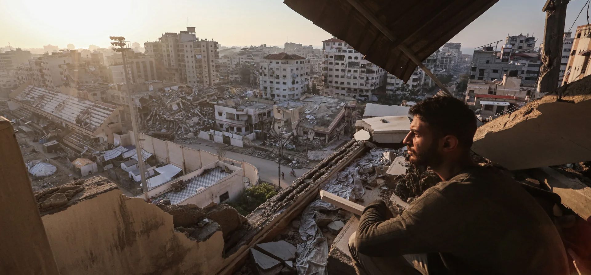 Palestinos caminan entre los escombros de edificios destruidos en la ciudad de Gaza, Al-Rimal, Franja de Gaza. Fotografía: APAImages/Shutterstock Palestinos caminan entre los escombros de edificios destruidos en la ciudad de Gaza, Al-Rimal, Franja de Gaza. Fotografía: APAImages/Shutterstock
