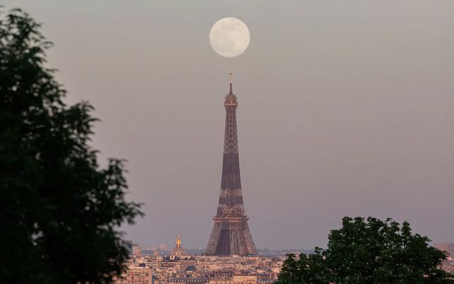La superluna se eleva sobre la Torre Eiffel en París.