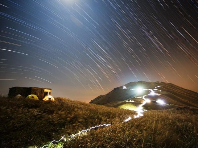 Gente y Espacio GANADOR DEL PREMIO GENTE Y ESPACIO Chap Him Wong (Hong Kong) y su fotografía “Sunset Peak Star Trail” han ganado el premio de “Gente y Espacio” por esta imagen de campistas refugiados del viento tras una hilera de casas de piedra cerca de Sunset Peak