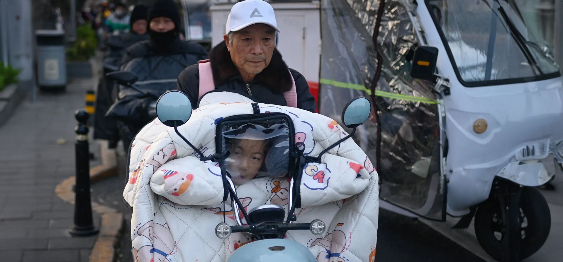 Un niño mira a través de la visera de un cortavientos en el camino a casa desde la escuela en un scooter, Pekín, China. Fotografía: Wang Zhao/AFP/Getty Images Un niño mira a través de la visera de un cortavientos en el camino a casa desde la escuela en un scooter, Pekín, China. Fotografía: Wang Zhao/AFP/Getty Images